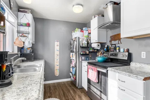 a kitchen with stainless steel appliances granite countertop a sink stove and refrigerator