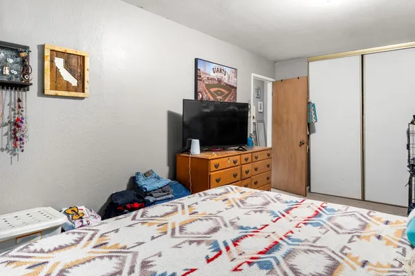 a bedroom with a bed and a flat screen tv