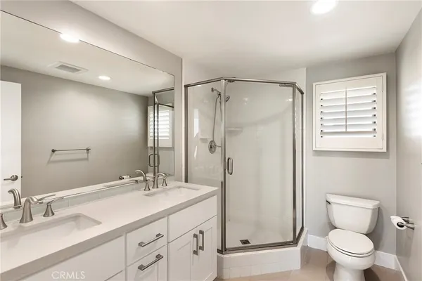 a bathroom with a granite countertop sink a toilet and shower