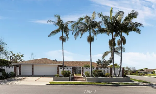 a palm tree sitting in front of a house with a palm tree