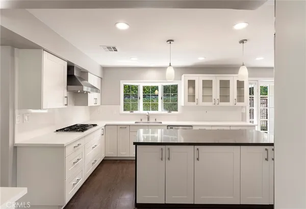 a kitchen with granite countertop white cabinets and window