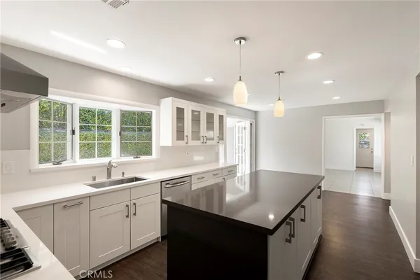 a kitchen with a sink center island and windows