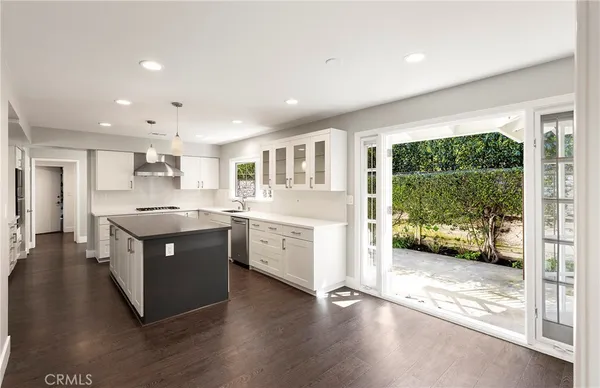 a large kitchen with stainless steel appliances granite countertop a large counter top a stove and a wooden floors