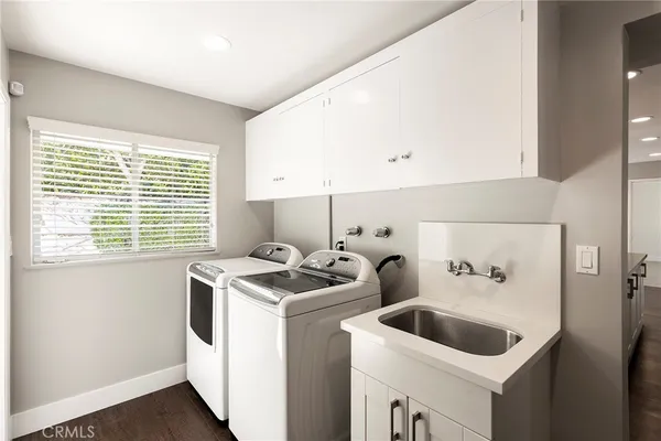 a utility room with sink dryer and washer