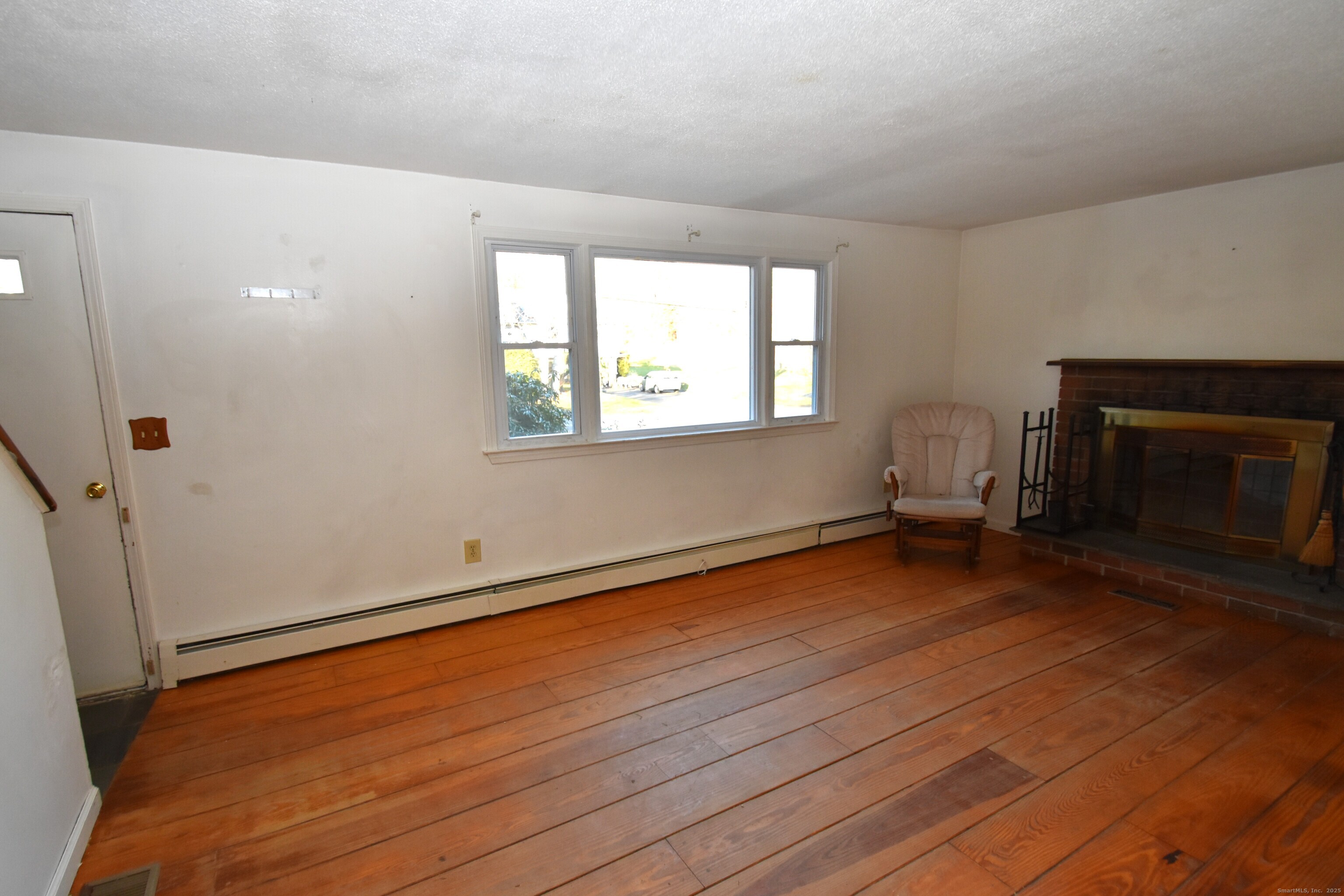 28 Hickory Road Colchester, CT 06415 - Photo 12 of 22 an empty room with wooden floor fireplace and windows