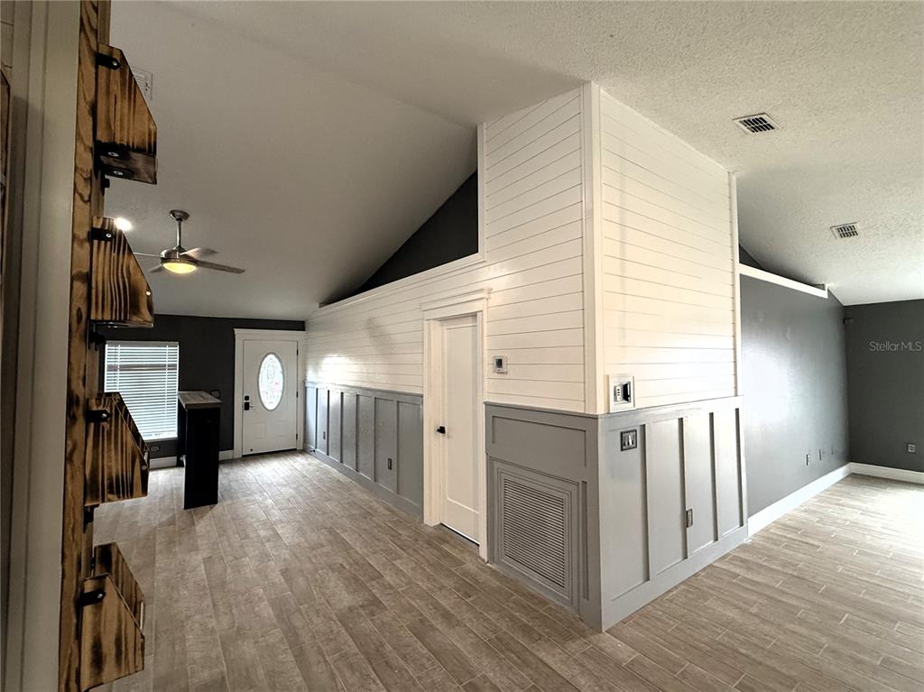 6172 Raleigh Street Spring Hill, FL 34606 - Photo 14 of 64 a view of a hallway with wooden floor and staircase