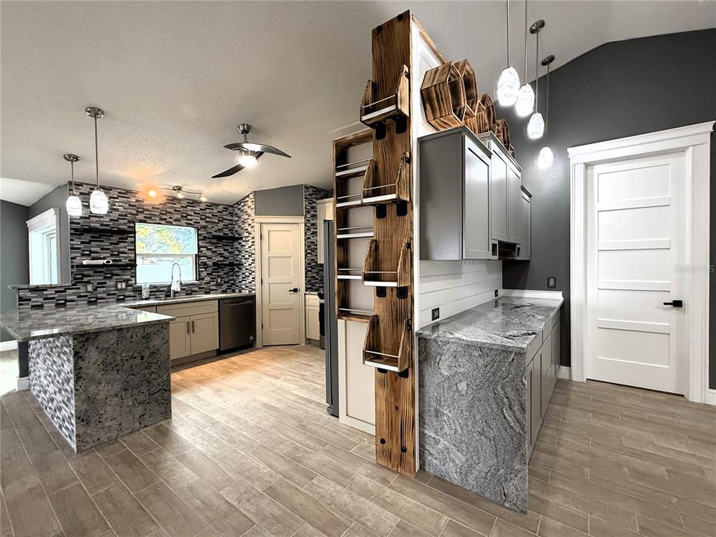 6172 Raleigh Street Spring Hill, FL 34606 - Photo 20 of 64 a kitchen with kitchen island a large counter top space appliances and cabinets