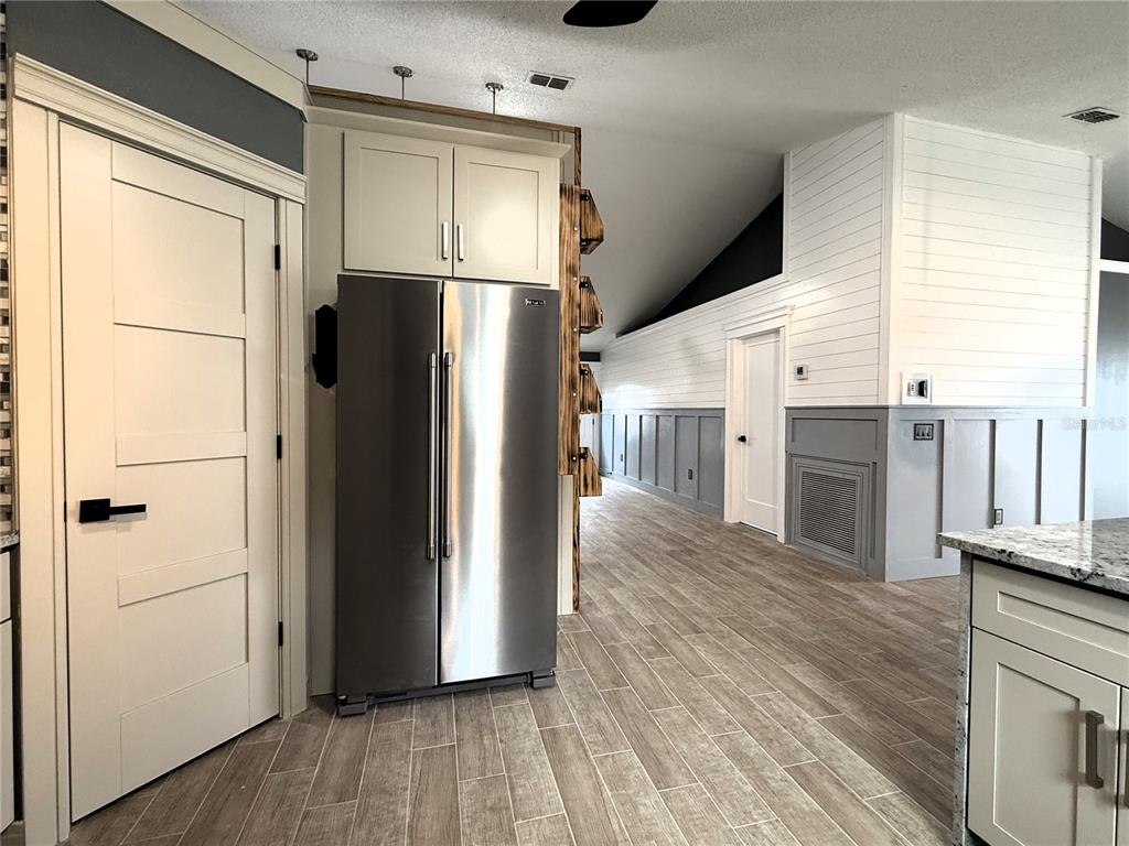 6172 Raleigh Street Spring Hill, FL 34606 - Photo 22 of 64 a view of a refrigerator in kitchen and wooden floor