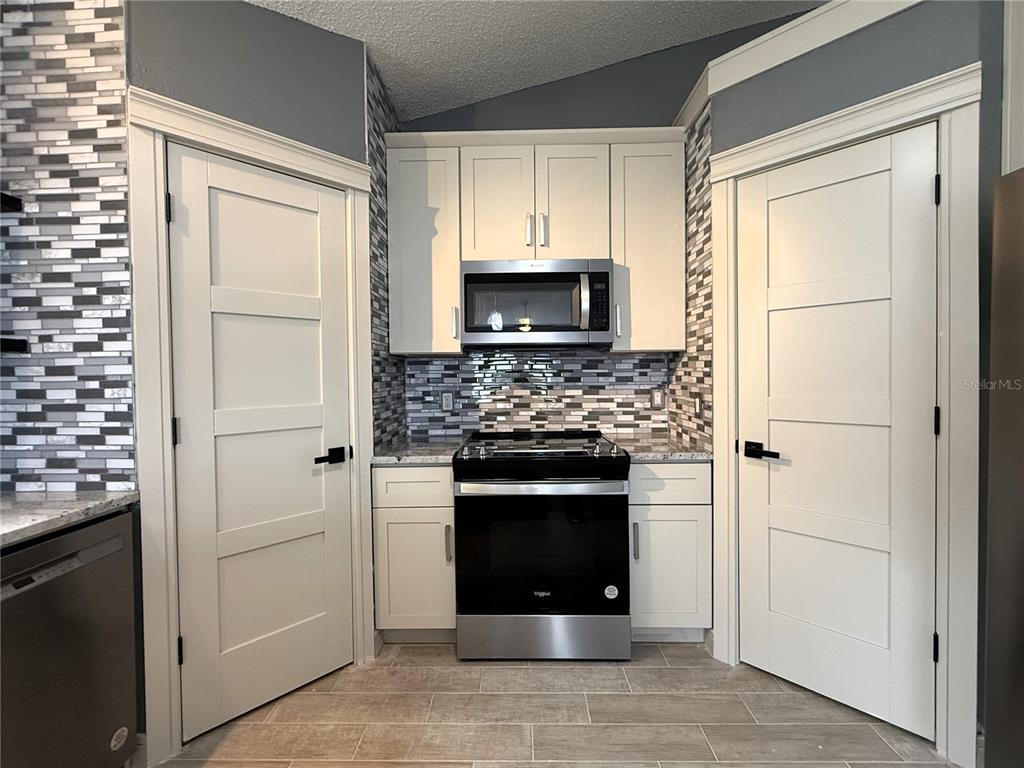 6172 Raleigh Street Spring Hill, FL 34606 - Photo 23 of 64 a kitchen with a refrigerator and a stove top oven