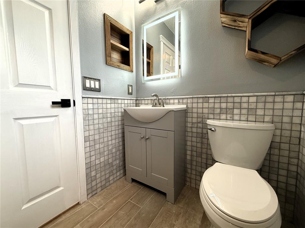 6172 Raleigh Street Spring Hill, FL 34606 - Photo 39 of 64 a bathroom with a toilet a sink and a microwave