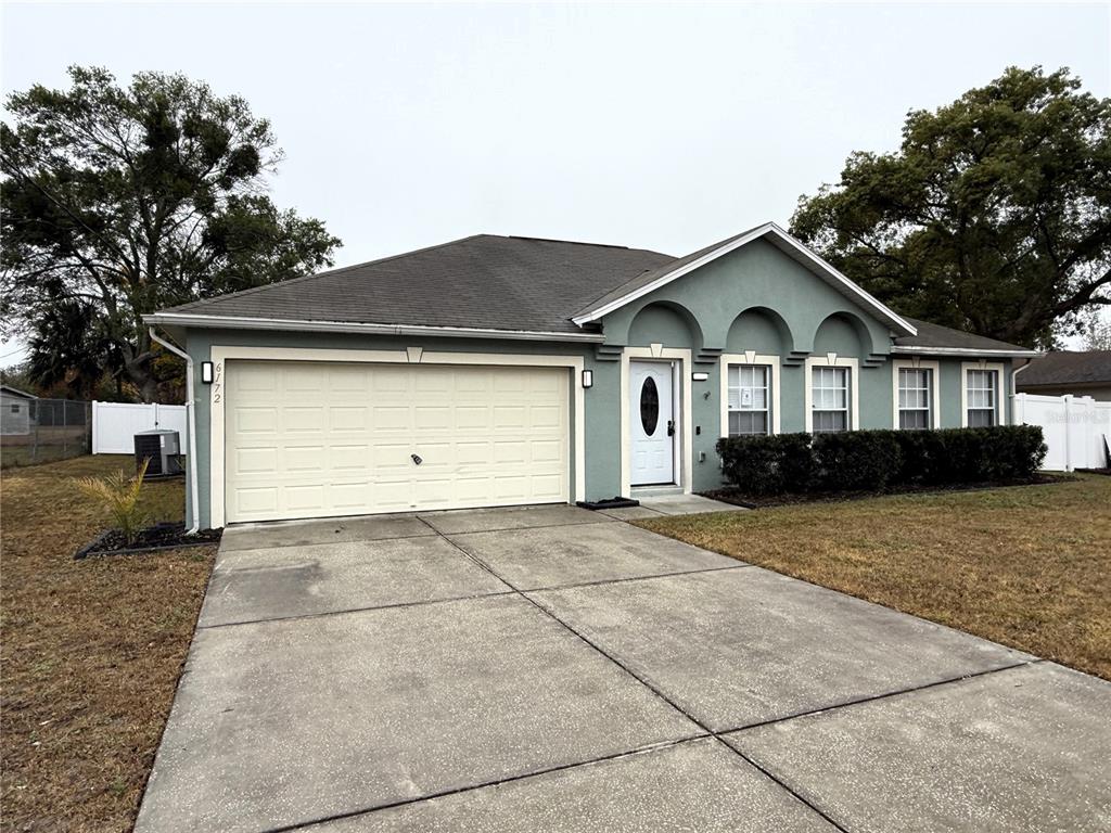 6172 Raleigh Street Spring Hill, FL 34606 - Photo 4 of 64 a front view of a house with a yard and garage