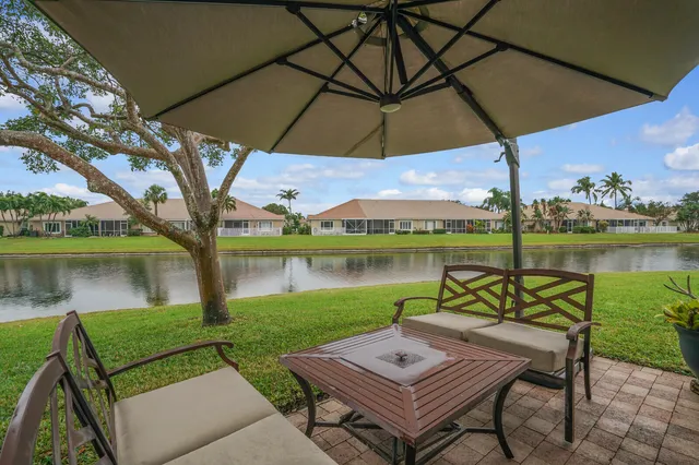 a view of a lake with couches and table under an umbrella