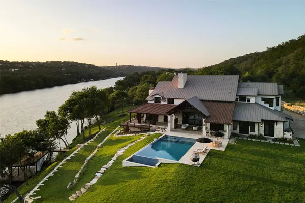 an aerial view of a house with swimming pool garden and patio