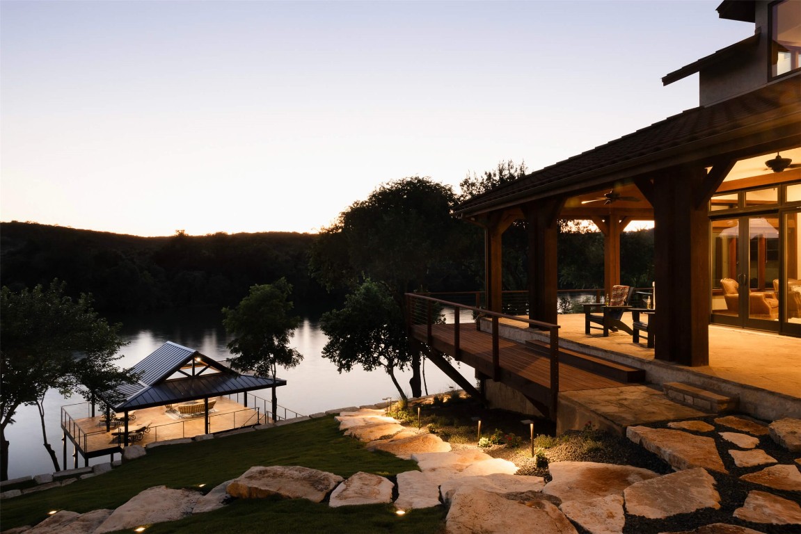 15016 Flat Top Ranch Road Austin, TX 78732 - Photo 17 of 40 a view of a patio with table and chairs potted plants with wooden floor and fence