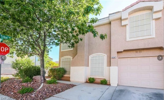 A well-maintained facade with arched windows and an attached garage offers inviting curb appeal.