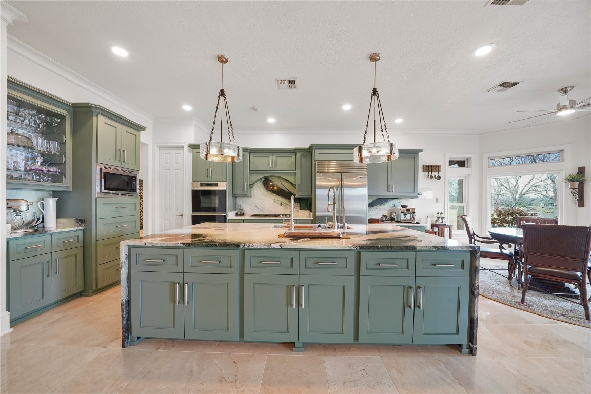 32134 Fulbrook Commons Fulshear, TX 77441 - Photo 11 of 49 Expansive cabinetry, premium finishes, and refined design details elevate the kitchen into a sophisticated culinary space anchored by a statement island.