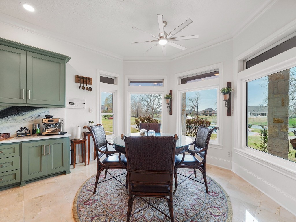 32134 Fulbrook Commons Fulshear, TX 77441 - Photo 13 of 49 The breakfast room is wrapped in panoramic views of the backyard and lake beyond, offering a light-filled setting for casual dining with a serene waterfront backdrop.