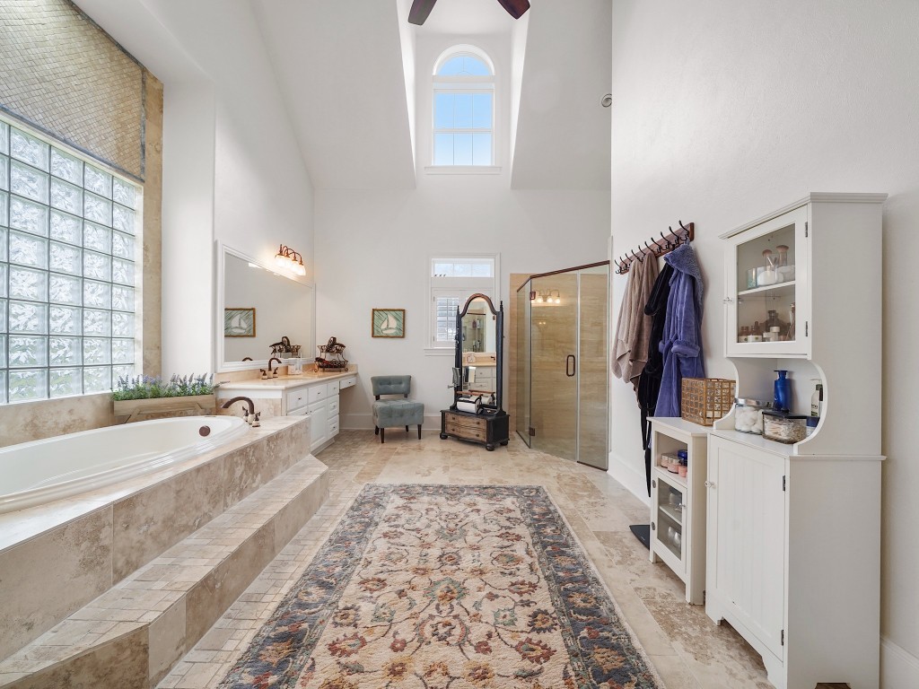 32134 Fulbrook Commons Fulshear, TX 77441 - Photo 21 of 49 The luxurious primary bath evokes a spa-like ambiance with expansive counters, refined finishes, and abundant natural light, creating a daily retreat within the home.