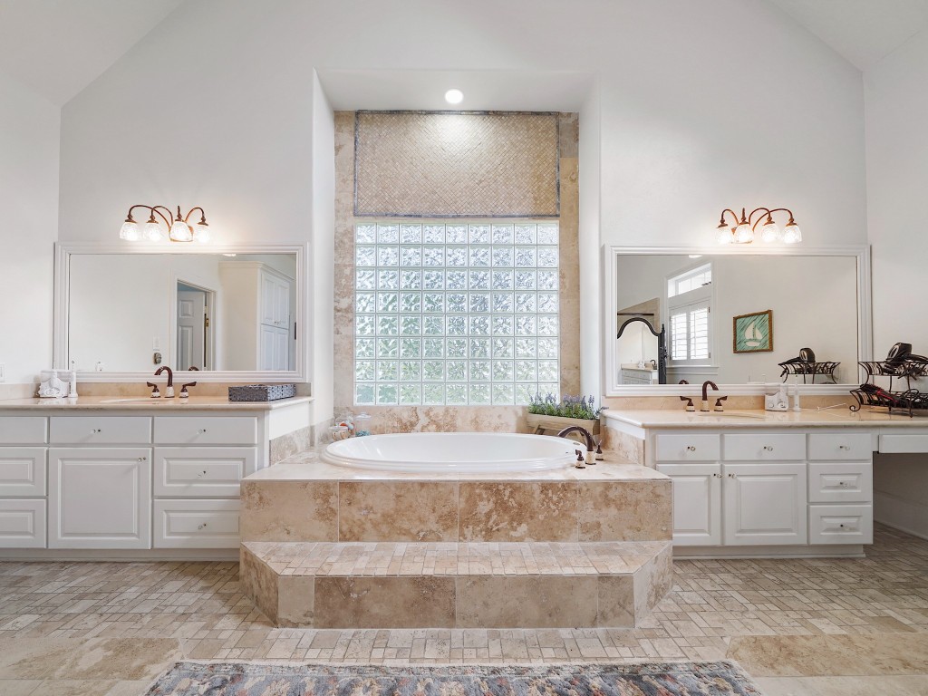 32134 Fulbrook Commons Fulshear, TX 77441 - Photo 22 of 49 A central jetted tub framed by glass block detailing anchors the ensuite, complemented by dual vanities and a generous layout designed for both elegance and function.
