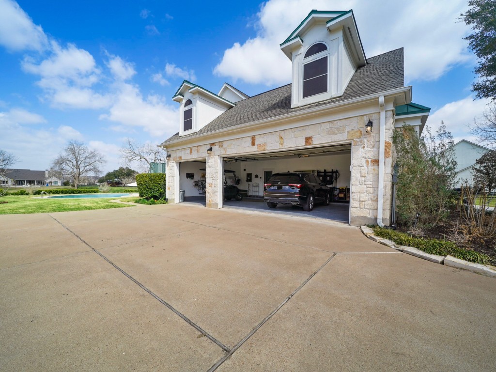 32134 Fulbrook Commons Fulshear, TX 77441 - Photo 34 of 49 The oversized three-car garage provides abundant space for vehicles and storage, designed to complement the scale of the estate.