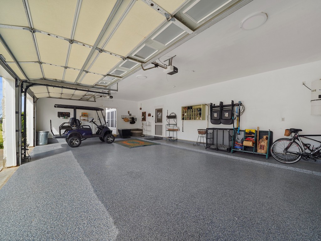 32134 Fulbrook Commons Fulshear, TX 77441 - Photo 35 of 49 Finished with durable epoxy flooring, this garage space blends function with polish, offering a clean and refined environment for vehicles, hobbies, or workshop needs.