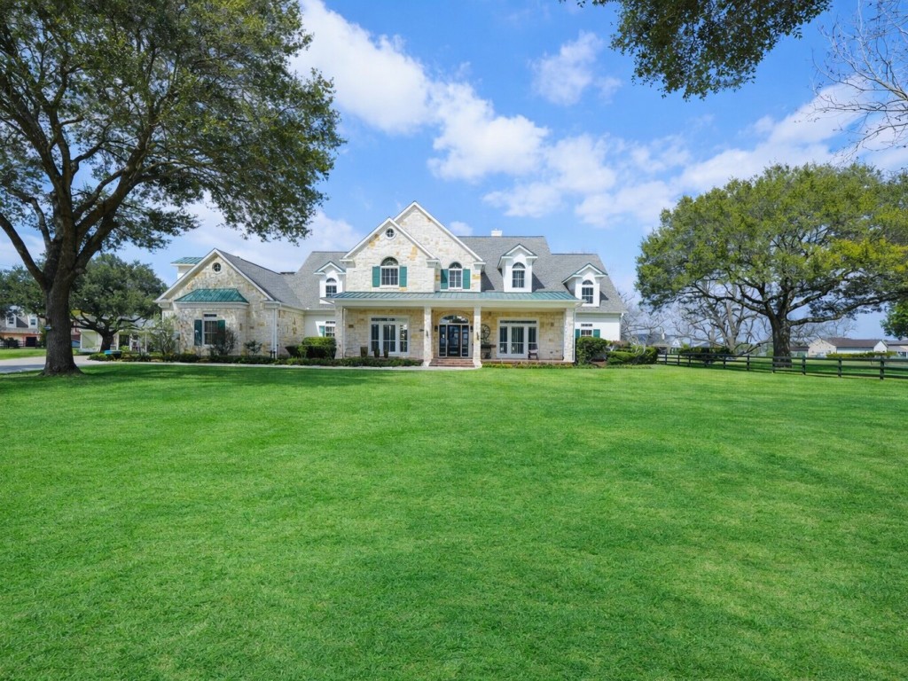 32134 Fulbrook Commons Fulshear, TX 77441 - Photo 4 of 49 Rolling green lawns and stately trees frame the home, creating a peaceful park-like setting that feels both refined and serene.