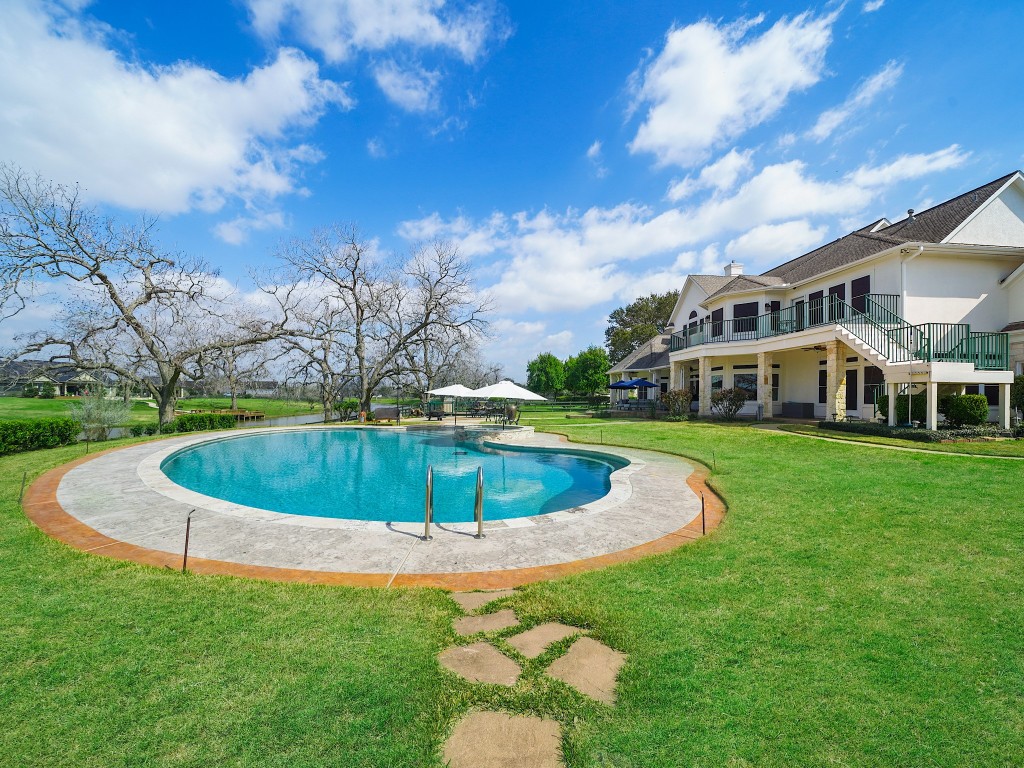 32134 Fulbrook Commons Fulshear, TX 77441 - Photo 46 of 49 The custom heated pool is a stunning focal point of the estate, thoughtfully designed with an automatic chemical system and positioned to capture serene waterfront views.
