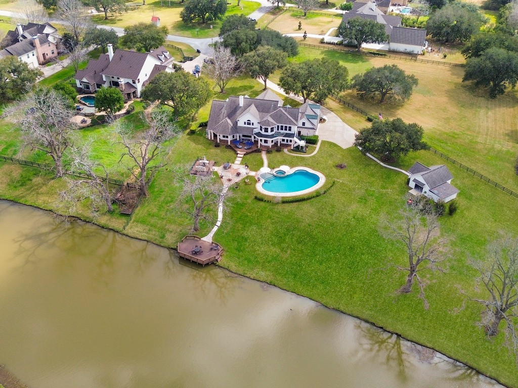 32134 Fulbrook Commons Fulshear, TX 77441 - Photo 47 of 49 From above, the full beauty of this 1.88-acre waterfront setting comes into view — private dock, custom pool, expansive lawn, and dedicated pool house all positioned to maximize both privacy and tranquil lake views.