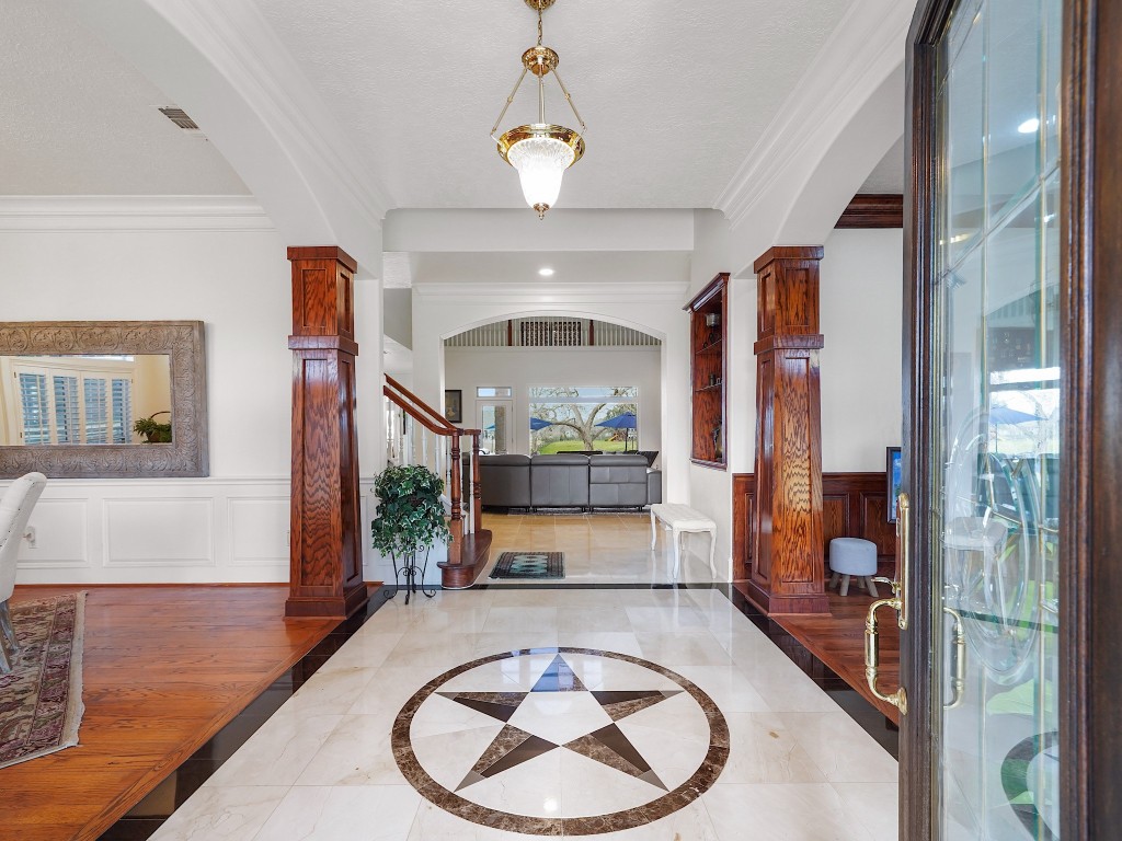 32134 Fulbrook Commons Fulshear, TX 77441 - Photo 6 of 49 A grand foyer welcomes you with soaring ceilings, rich millwork, and warm finishes. The dramatic entry sets an elegant tone while offering a glimpse of the scale and refinement that define the home.