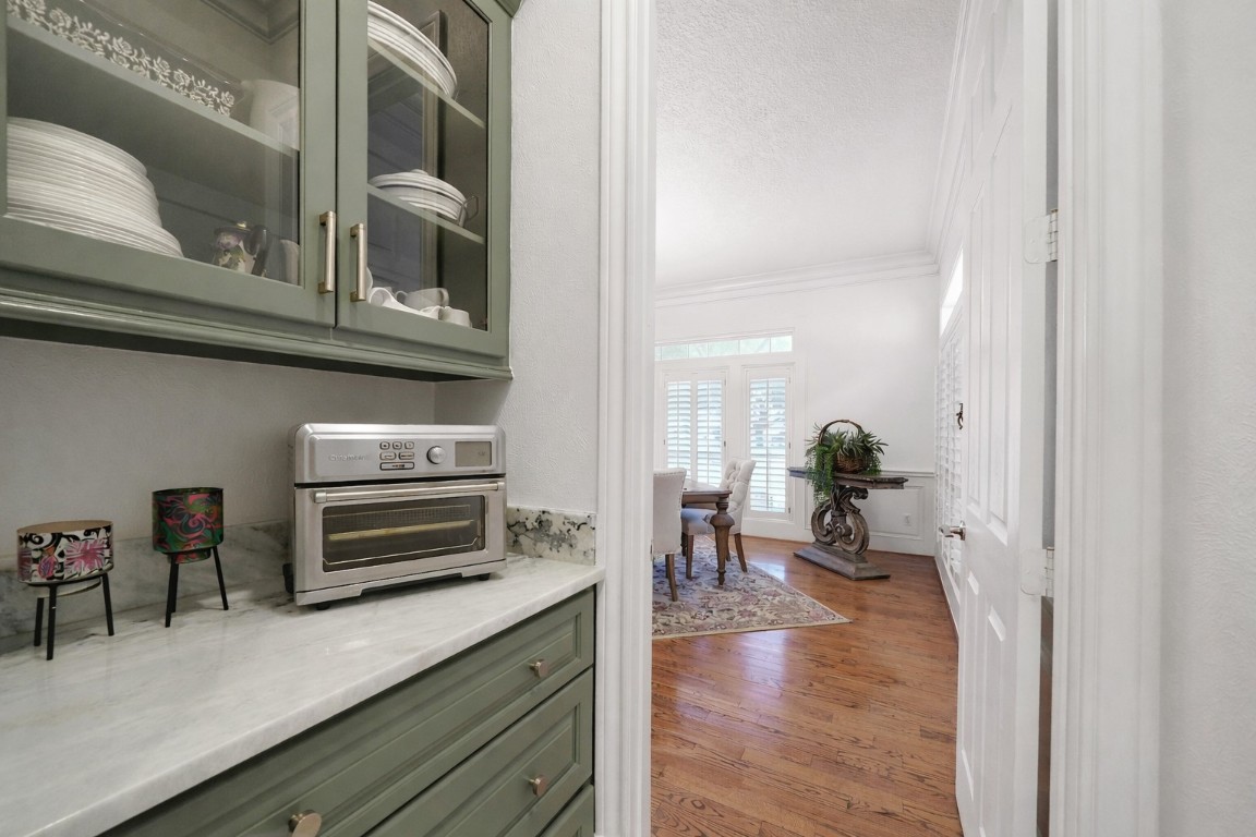 32134 Fulbrook Commons Fulshear, TX 77441 - Photo 9 of 49 A beautifully designed butler’s pantry seamlessly connects the dining room to the kitchen, enhancing flow and functionality for effortless entertaining.