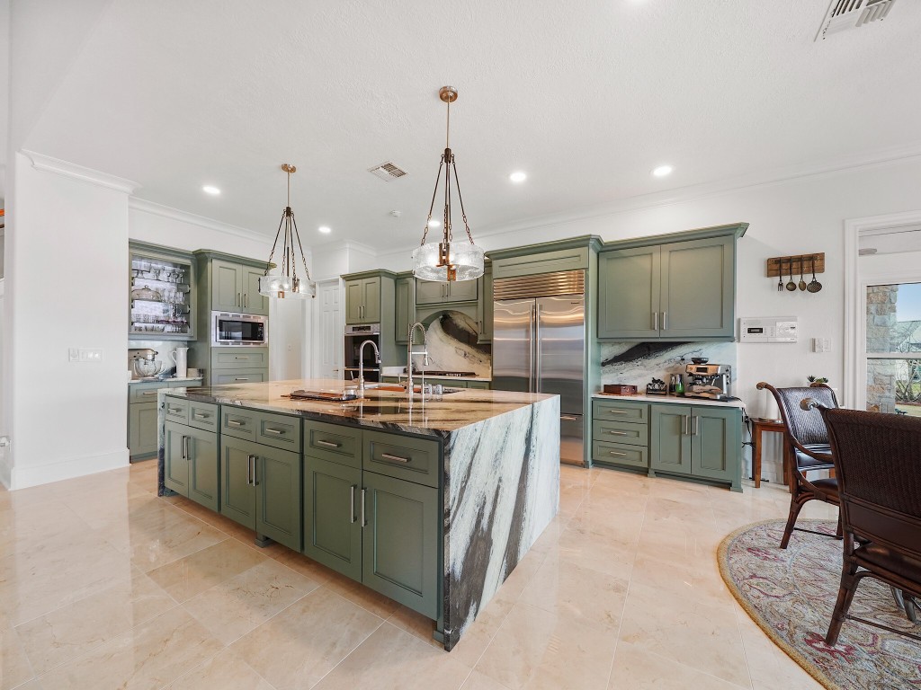 32134 Fulbrook Commons Fulshear, TX 77441 - Photo 10 of 49 The reimagined kitchen is a true showpiece, featuring custom cabinetry, a dramatic waterfall island, Sub-Zero refrigeration, Dacor double ovens, and a JennAir downdraft range — thoughtfully designed for both elevated entertaining and everyday living.