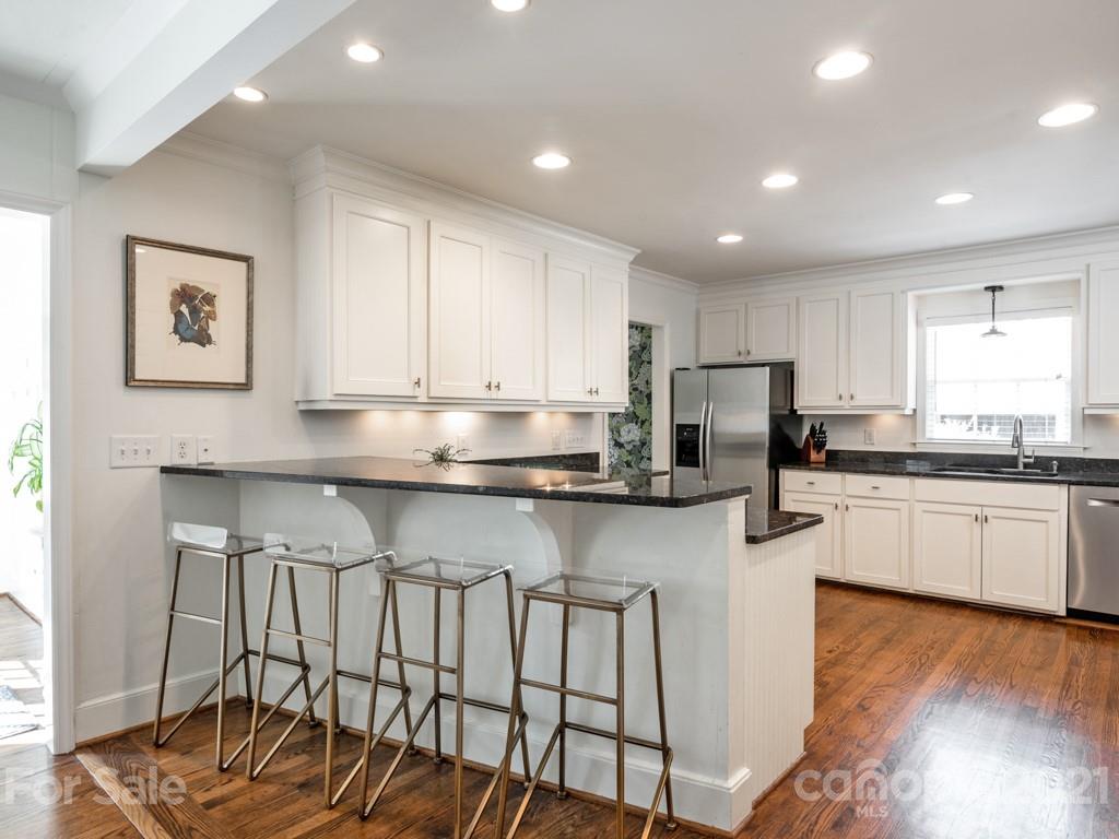 1315 Ferncliff Road Charlotte, NC 28211 - Photo 16 of 44 a kitchen with granite countertop white cabinets and stainless steel appliances