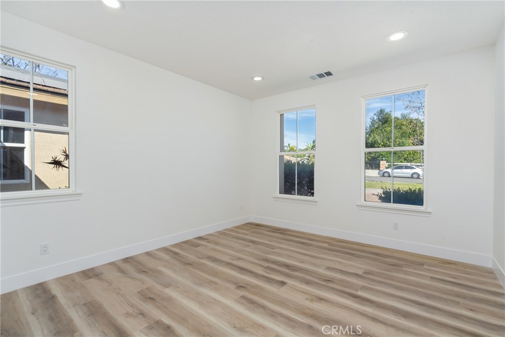 17741 Laurel Grove Road Riverside, CA 92504 - Photo 15 of 62 a view of an empty room with a window and wooden floor