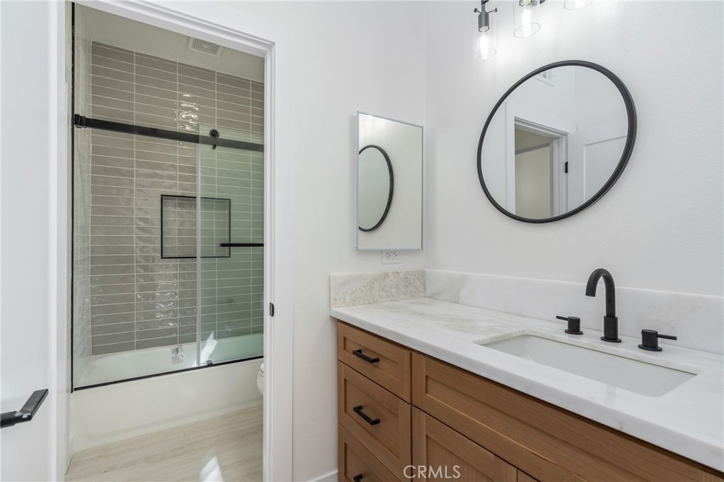 17741 Laurel Grove Road Riverside, CA 92504 - Photo 21 of 62 a bathroom with a granite countertop sink mirror and vanity