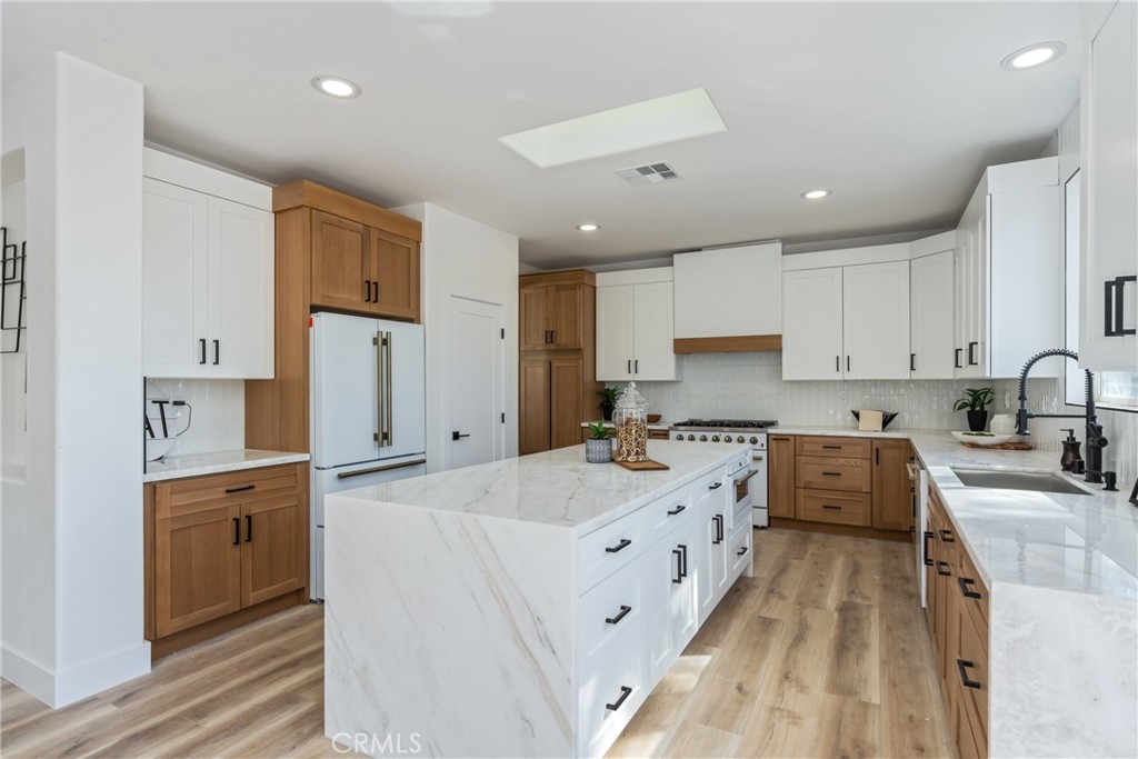 17741 Laurel Grove Road Riverside, CA 92504 - Photo 43 of 62 a large white kitchen with stainless steel appliances granite countertop a lot of counter space and wooden floors