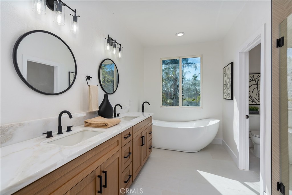 17741 Laurel Grove Road Riverside, CA 92504 - Photo 51 of 62 a bathroom with a double vanity sink and a bathtub