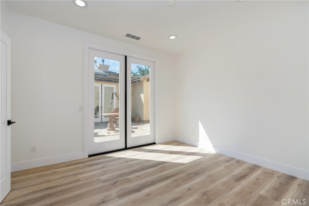 17741 Laurel Grove Road Riverside, CA 92504 - Photo 9 of 62 an empty room with wooden floor and windows