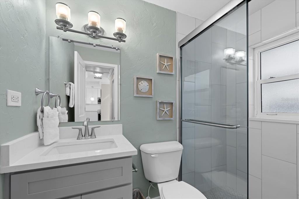 5830 Midnight Pass Road, Unit 52 Sarasota, FL 34242 - Photo 15 of 32 a bathroom with a toilet sink and shower
