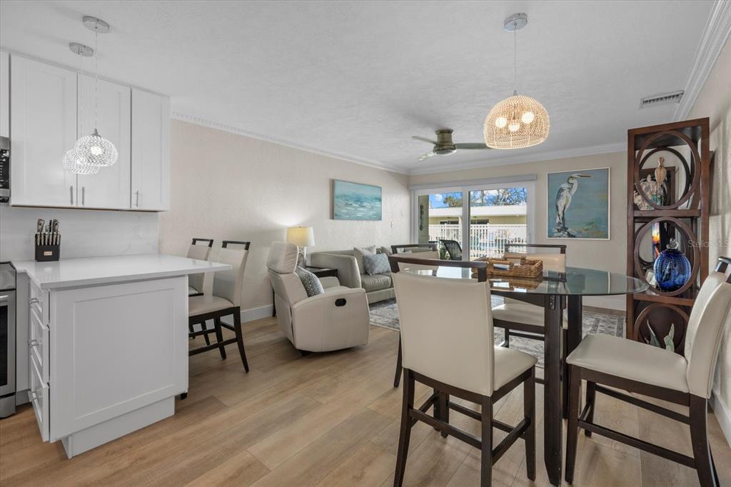 5830 Midnight Pass Road, Unit 52 Sarasota, FL 34242 - Photo 3 of 32 a view of a dining room with furniture and wooden floor