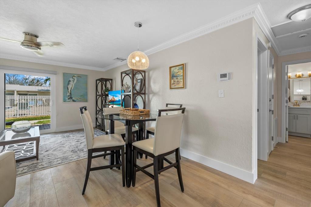5830 Midnight Pass Road, Unit 52 Sarasota, FL 34242 - Photo 4 of 32 a view of a dining room with furniture and wooden floor