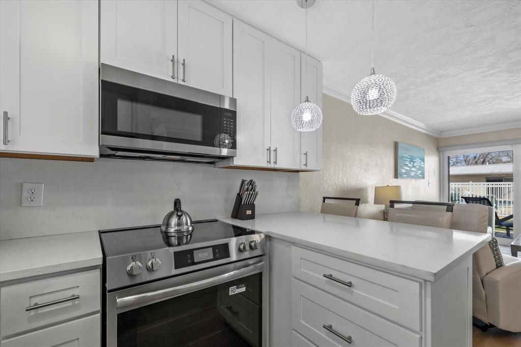 5830 Midnight Pass Road, Unit 52 Sarasota, FL 34242 - Photo 10 of 32 a kitchen with a stove microwave and cabinets