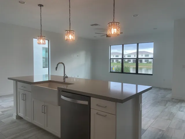 a large kitchen with kitchen island a sink stainless steel appliances and cabinets