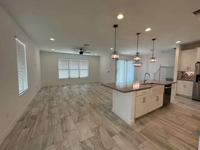 a large kitchen with stainless steel appliances kitchen island a large counter top and a wooden floors