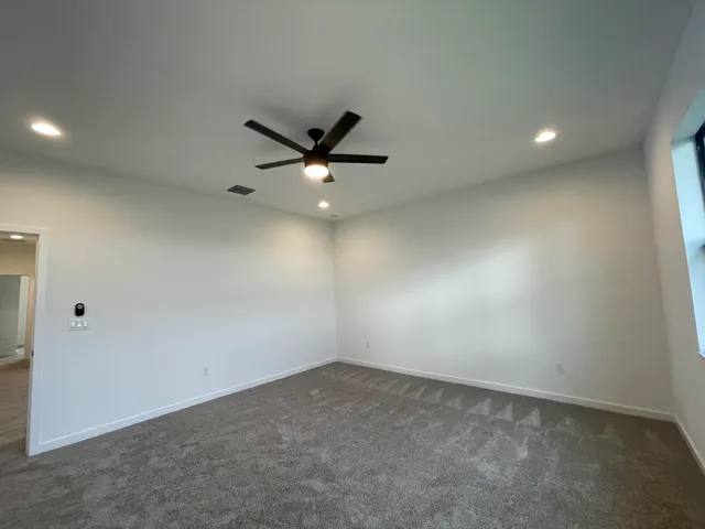 an empty room with closet and a ceiling fan