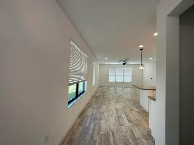 a kitchen with stainless steel appliances kitchen island granite countertop a refrigerator a stove and a sink with wooden floor