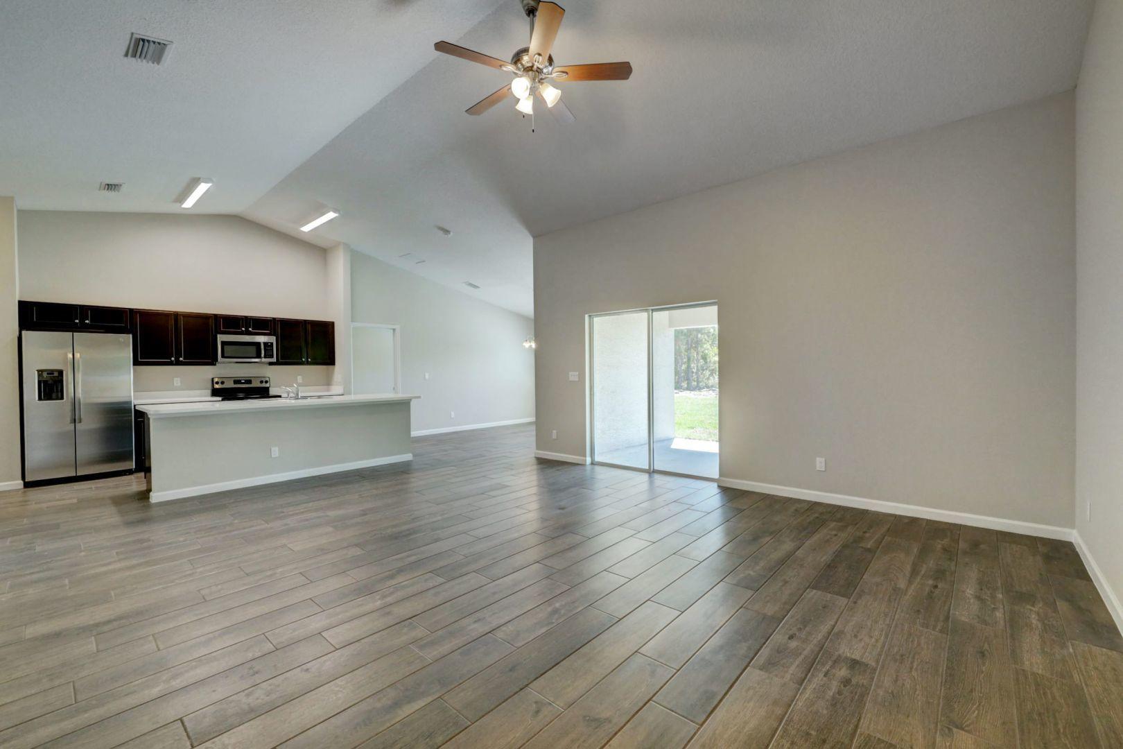 444 Southwest Log Drive Port St. Lucie, FL 34953 - Photo 11 of 54 a view of empty room with wooden floor and ceiling fan