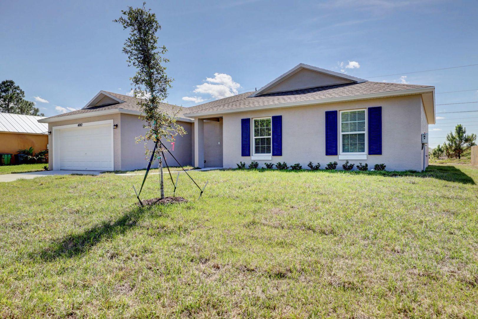 444 Southwest Log Drive Port St. Lucie, FL 34953 - Photo 2 of 54 a house view with a garden space