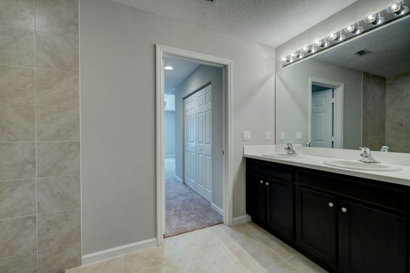 444 Southwest Log Drive Port St. Lucie, FL 34953 - Photo 23 of 54 a bathroom with a double vanity sink and a mirror