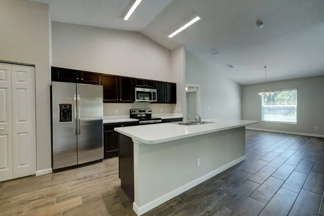 a kitchen with stainless steel appliances a refrigerator sink and microwave
