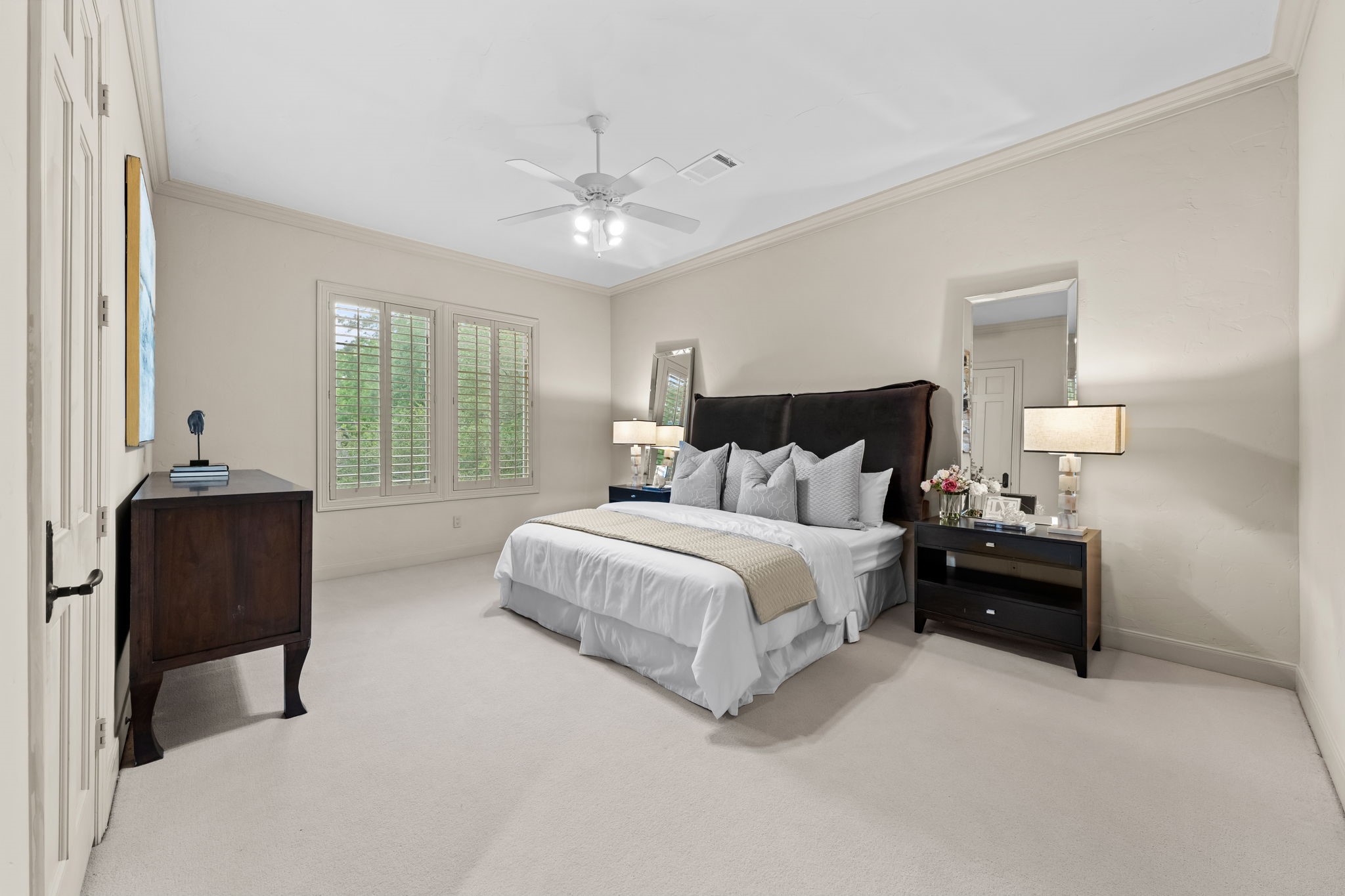 6 Mott Lane Houston, TX 77024 - Photo 38 of 50 Spacious secondary bedroom featuring a neutral palette, plush carpeting, and abundant natural light throughout planation shutters. Generous layout offers flexibility for guests or family.